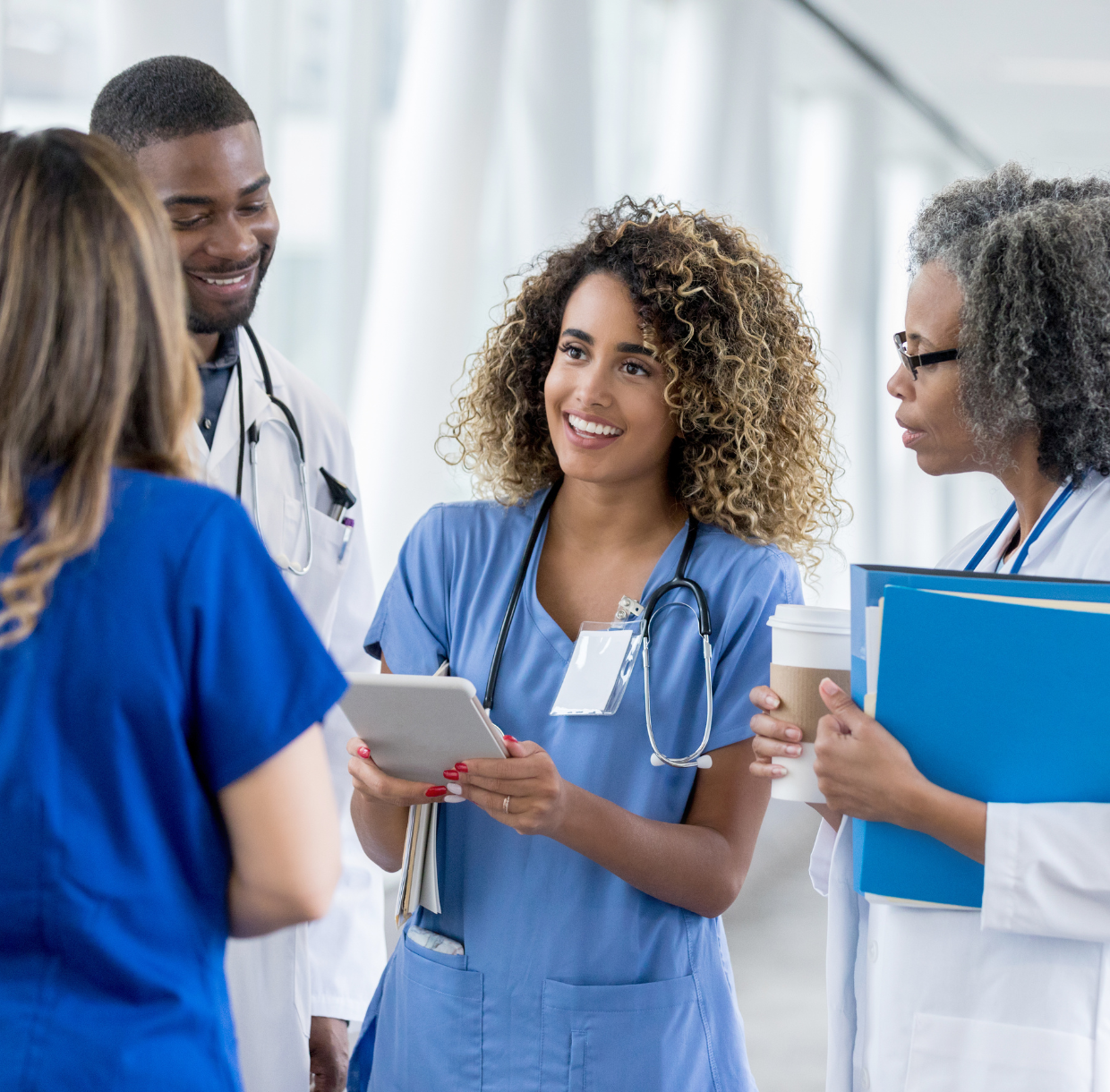 Healthcare manager reviewing staff schedules with a clinical team in a hospital